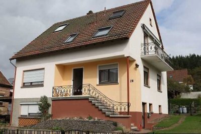 Freistehendes Einfamilienhaus mit großzügigen Rasengrundstück und einem Carport.