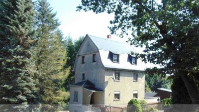 Einfamilienhaus mit großer Garage und Waldgrundstück.