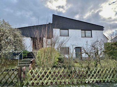 Wunderbares Einfamilienhaus mit besonderer Architektur,
praktischer Einliegerwohnung & Garagen